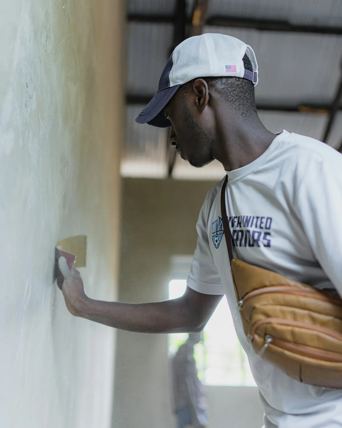 An artisan carefully preparing a wall surface
